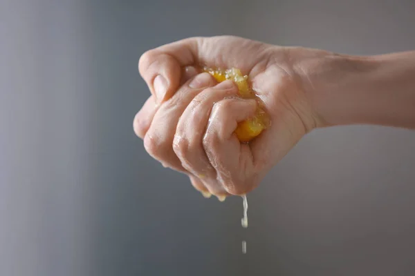 Рука сжимает половину лимона — стоковое фото