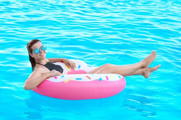 Beautiful young girl with inflatable donut — Stock Photo, Image