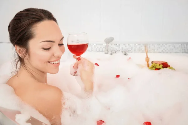 Hermosa mujer con copa de vino tinto en la bañera — Foto de Stock