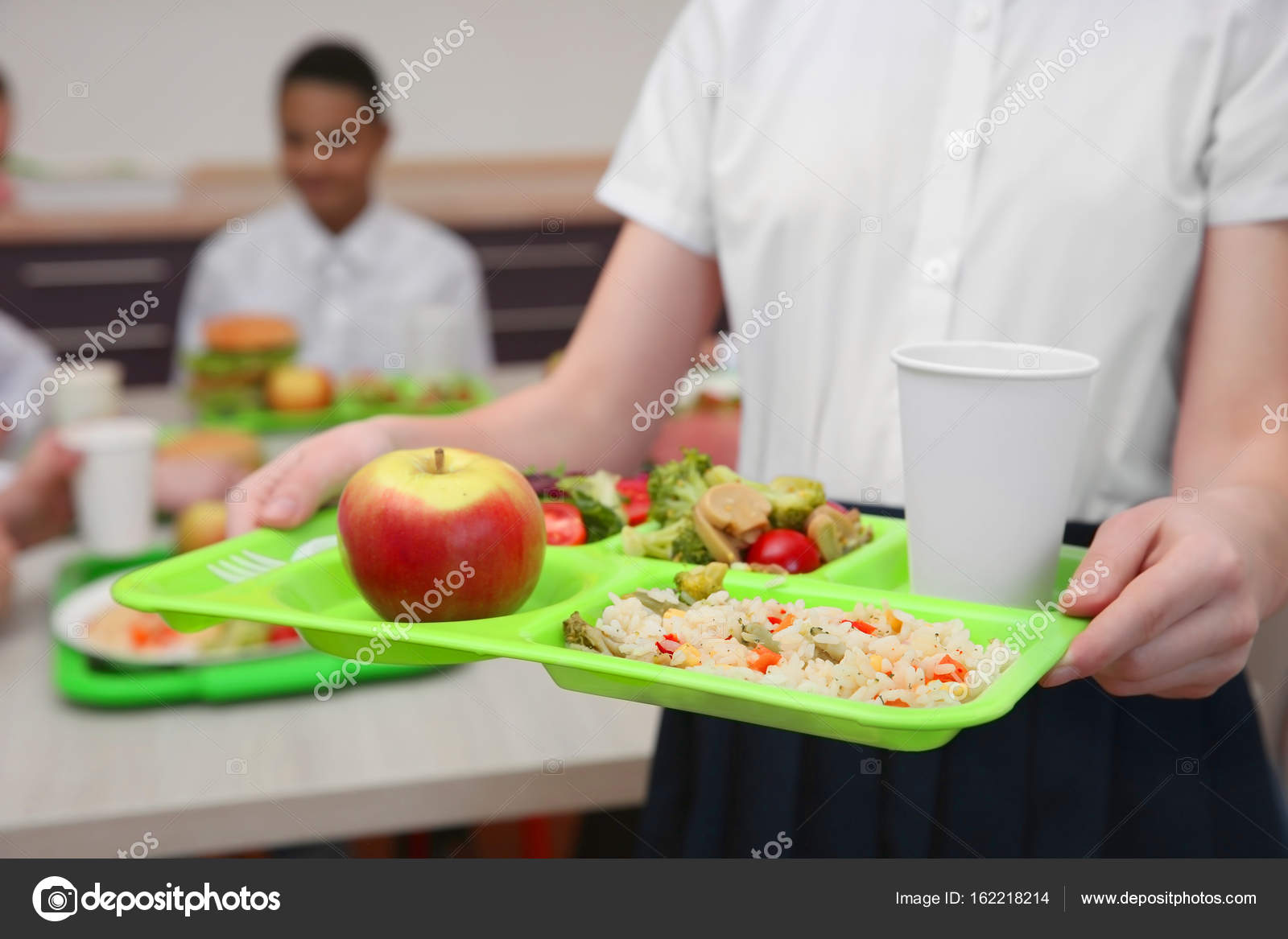 Chica sosteniendo la bandeja con deliciosa comida en el comedor ... Chica sosteniendo la bandeja con deliciosa comida en el comedor ...