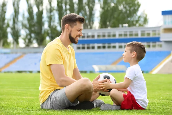 Papà e figlio con pallone da calcio nello stadio — Foto Stock