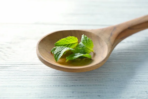 Wooden spoon with leaves of lemon balm — Stock Photo, Image