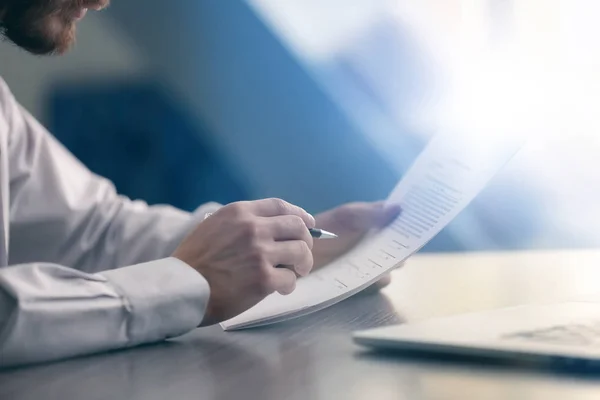 Empresário que lê documentos à mesa — Fotografia de Stock