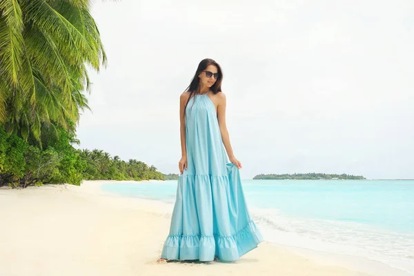 Tropik tatil beldesindeki sahilde güzel genç bir kadın.