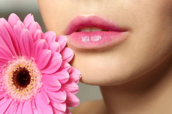 Vrouw met mooie lippen en bloem — Stockfoto