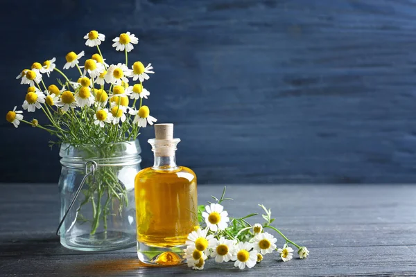 Essential oil and chamomile flowers — Stock Photo, Image
