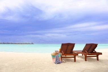 Ahşap şezlong plaj aksesuarları ile denizde tatil