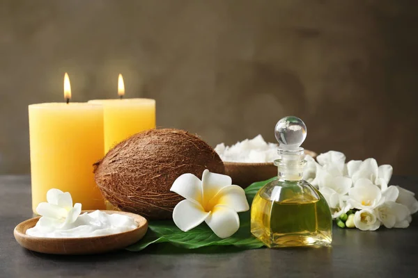 Прекрасная спа-композиция с кокосовыми продуктами для тела и свечами на столе — стоковое фото