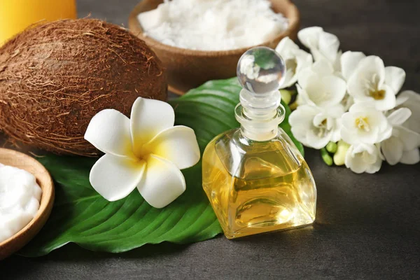 Vackra spa sammansättning med olja i flaskan och kokos på bord — Stockfoto