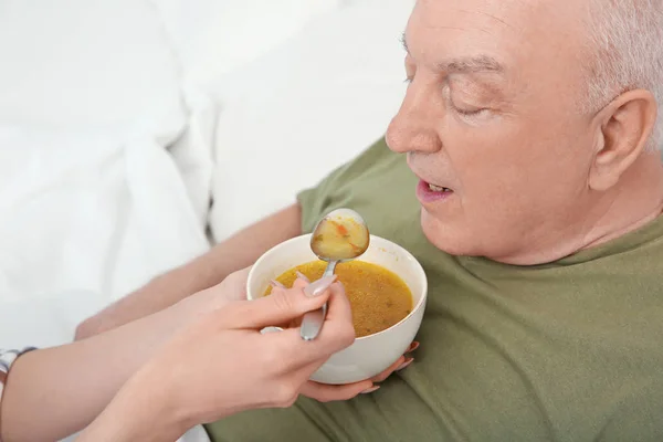 Vrijwilliger voeding oudere man — Stockfoto