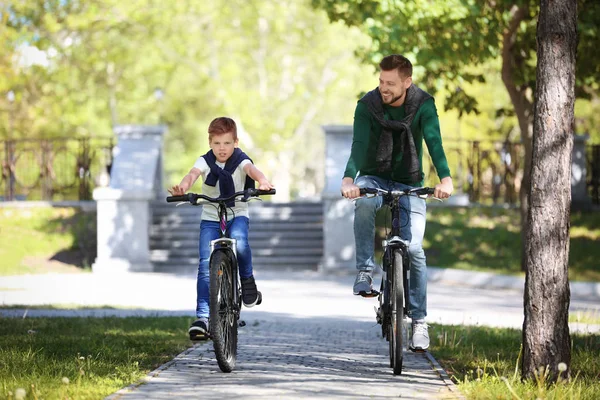 Папа и сын катаются на велосипедах — стоковое фото