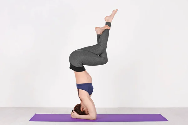 Giovane donna che pratica yoga su sfondo bianco — Foto Stock