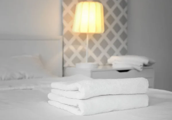 Stack of towels on bed — Stock Photo, Image