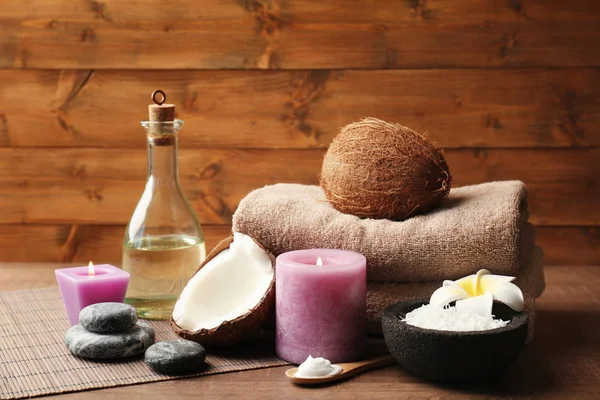 Прекрасная спа-композиция с кокосовыми продуктами для тела и свечами на столе — стоковое фото