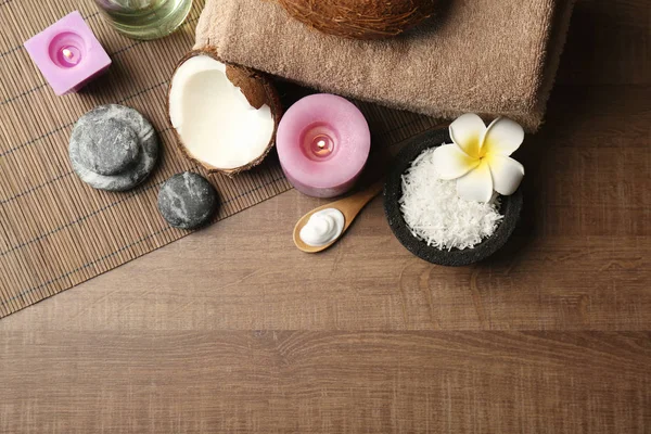 Belle composition spa avec des produits de soins du corps à la noix de coco et des bougies sur la table — Photo