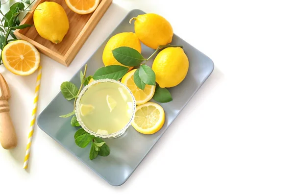 Platter with glass of juice and lemons — Stock Photo, Image