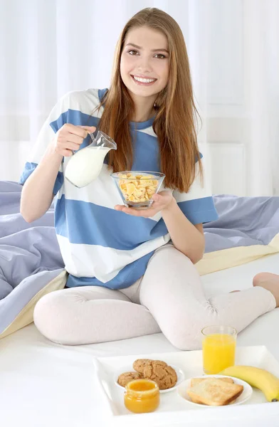 Joven hermosa mujer desayunando en la cama — Foto de Stock