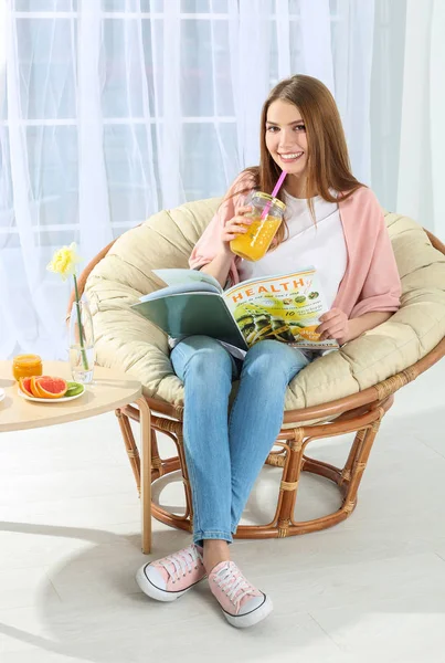 Молода красива жінка снідає в кріслі — стокове фото