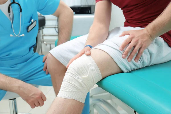 Ortopedista examinando paciente en clínica — Foto de Stock