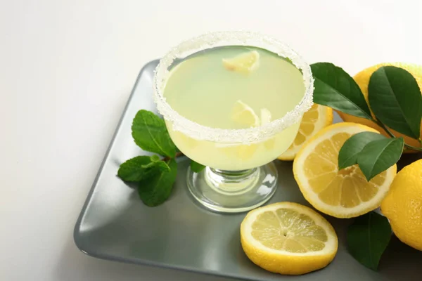 Platter with glass of juice and lemons — Stock Photo, Image