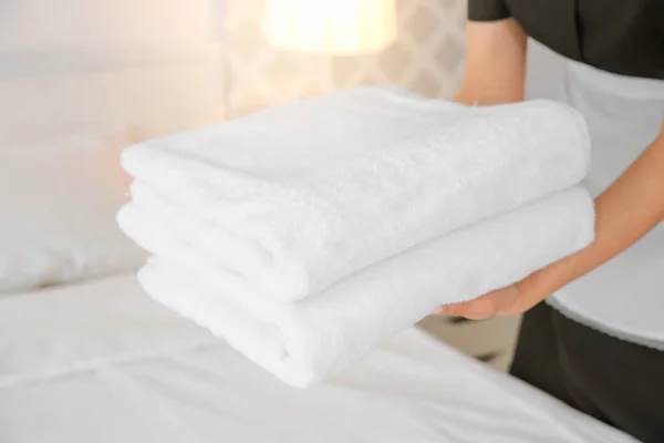 Maid holding stack of towels — Stock Photo, Image