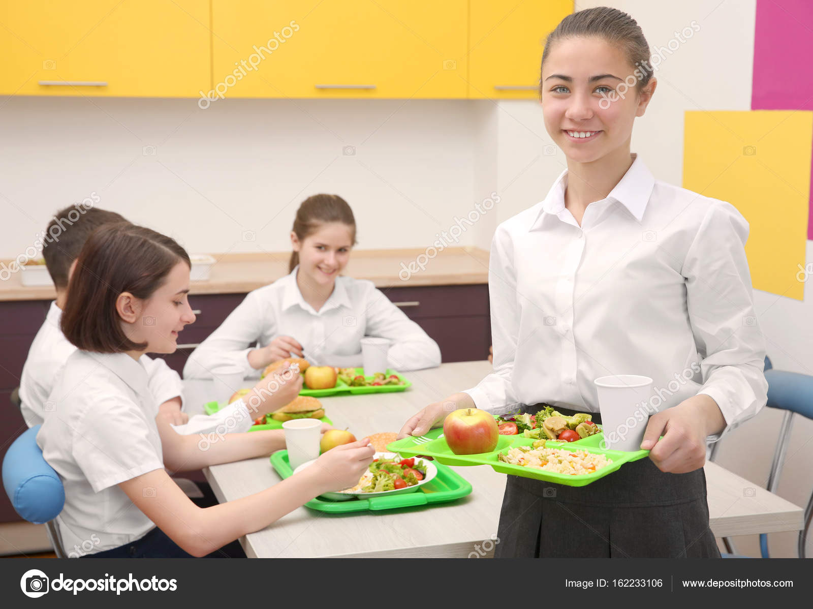 Linda chica sosteniendo la bandeja con deliciosa comida en comedor ... Linda chica sosteniendo la bandeja con deliciosa comida en comedor ...