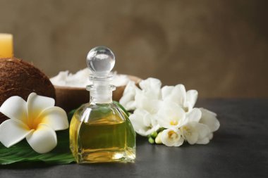 Hindistan cevizi yağı ve çiçekler ile şişe 