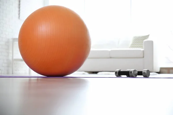 Rubber ball and dumbbells — Stock Photo, Image