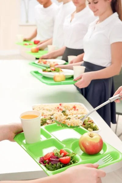 Genç kadın, kantin liseli kız için öğle yemeği servisi