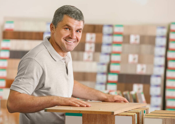 Зрелый человек выбирает образцы ламината
 