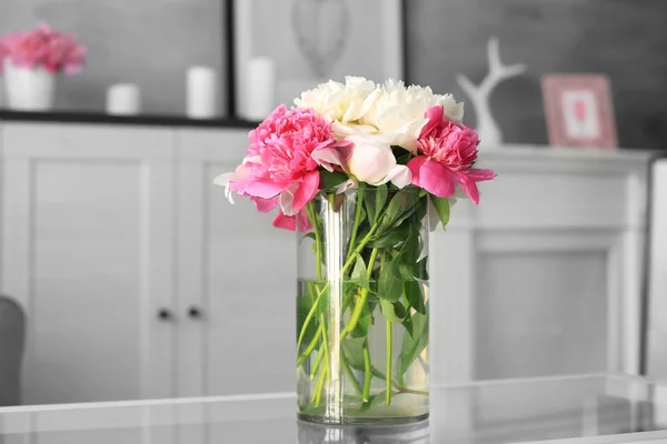 Glass vase with beautiful peonies on table — Stock Photo, Image