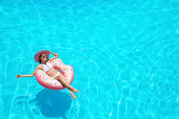 Jonge vrouw op opblaasbare donut — Stockfoto