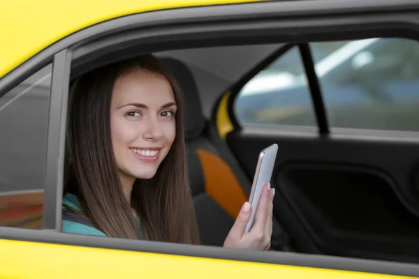 Kvinna som använder telefon i taxi — Stockfoto