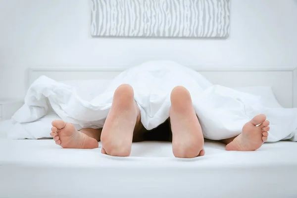 Kaki pasangan berhubungan seks di bawah selimut di rumah — Stok Foto