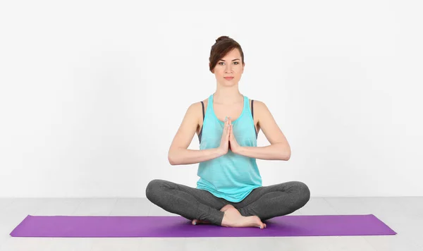 Mujer joven practicando yoga sobre fondo blanco —  Fotos de Stock