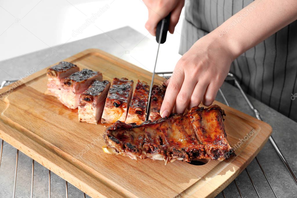 Woman cutting pork ribs 