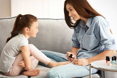 Genç kadın ve küçük kızı evde pedikür yapıyor