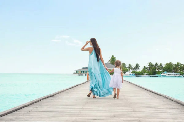 Vacker ung kvinna med sin dotter på sea resort — Stockfoto