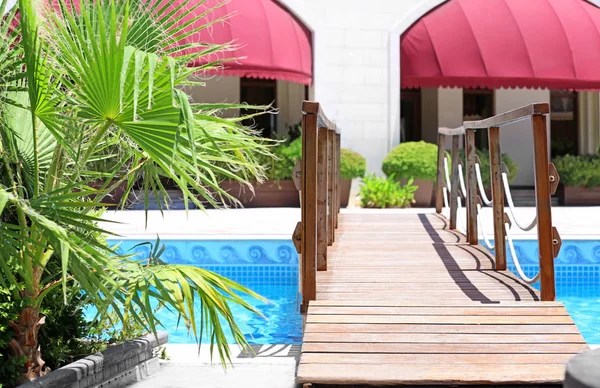 Puente de madera sobre piscina en hotel de lujo — Foto de Stock