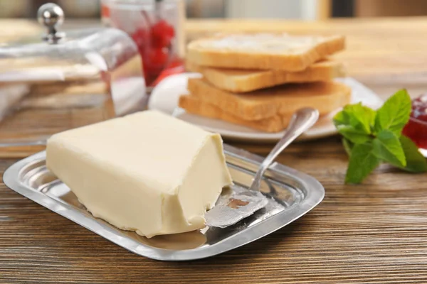 Pedazo de mantequilla en el plato — Foto de Stock