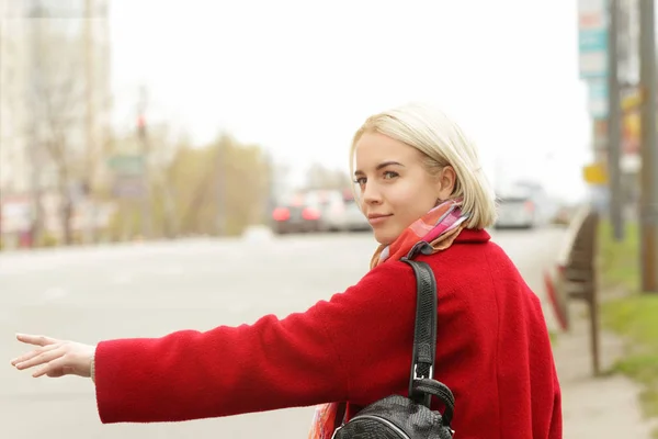 Молодая красивая женщина ловит такси на улице — стоковое фото