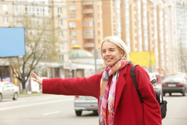 Junge schöne Frau fängt Taxi auf der Straße — Stockfoto