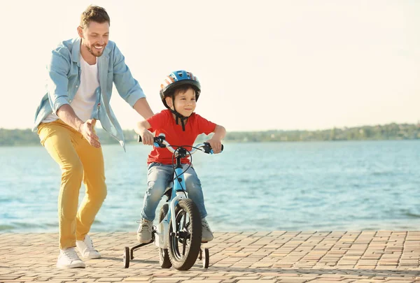 Человек учит сына ездить на велосипеде — стоковое фото