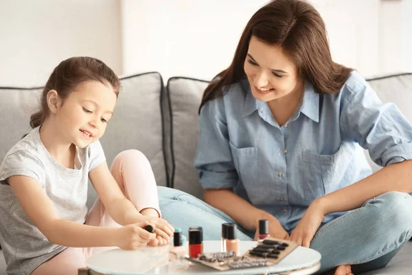 Genç kadın ve küçük kızı evde pedikür yapıyor