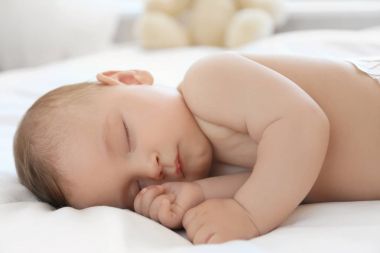 Evdeki yatakta uyuyan tatlı bir bebek.