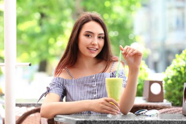 Genç ve güzel kadın içme smoothie Cafe