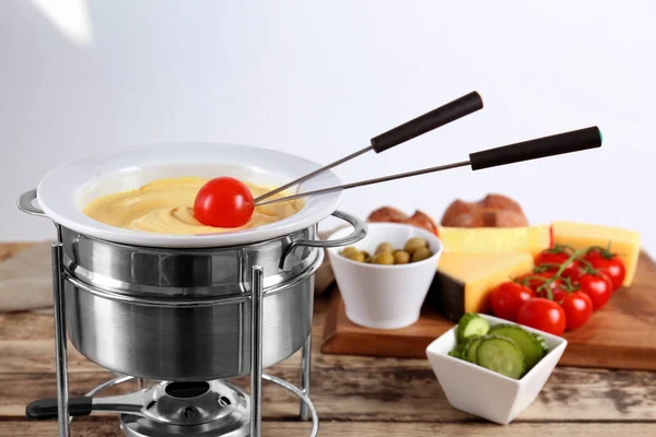 Tomato and cheese fondue in pot on kitchen table — Stock Photo, Image