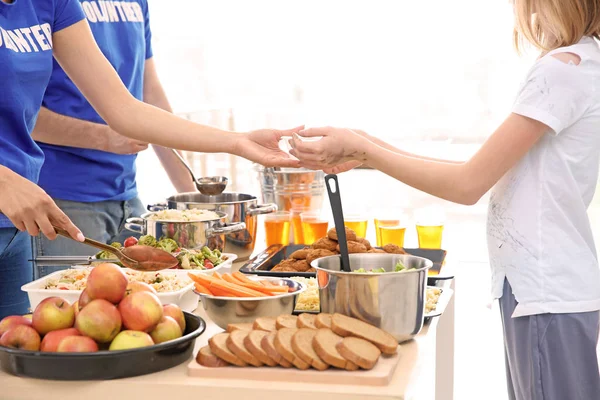 Volunteers giving food to poor girl. Poverty concept — Stock Photo, Image