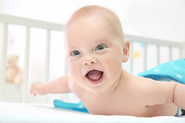 Эмоциональный ребенок лежит в колыбели
