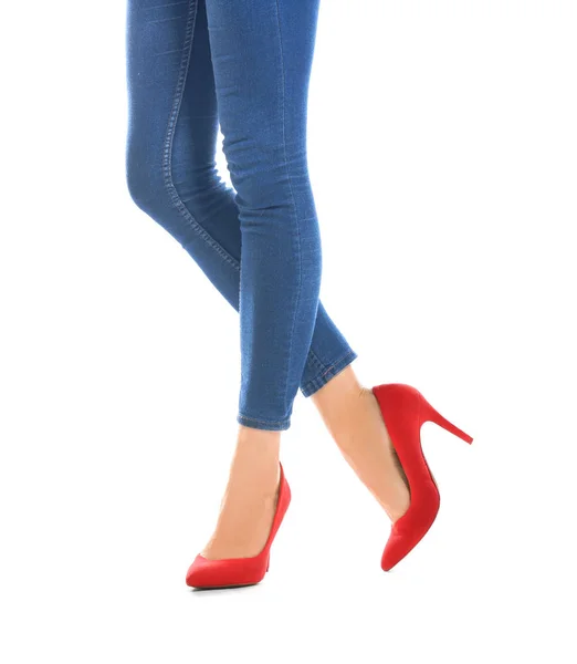 Тонкі жіночі ноги на високих підборах і джинси на білому тлі — стокове фото